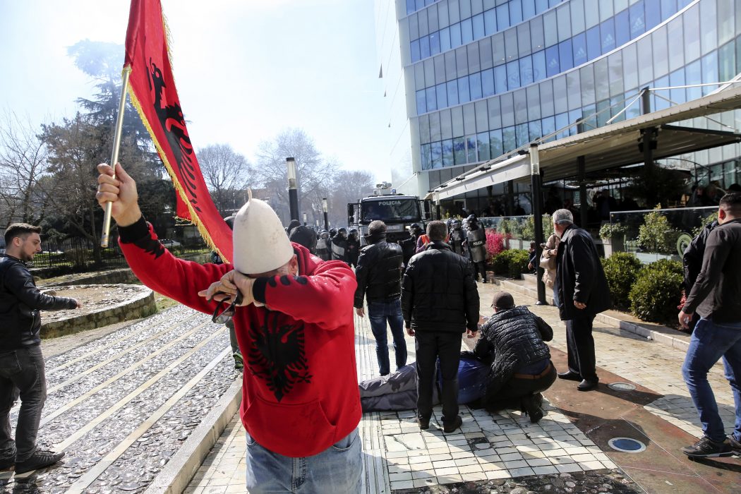 En demonstrant håller sig för ögonen sedan polisen skjutit tårgas.