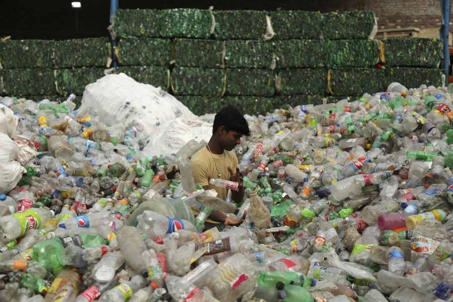 En arbetare i delstaten Jammu och Kashmir i Indien sorterar använda plastflaskor som ska skickas vidare till en återvinningsanläggning.
