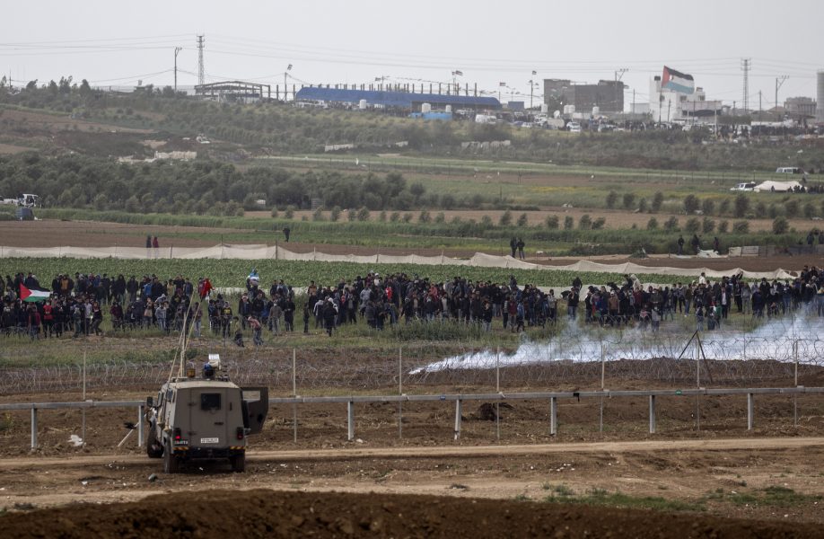 Israeliska soldater och palestinska demonstranter vid gränsen mellan Israel och Gazaremsan på lördagen.