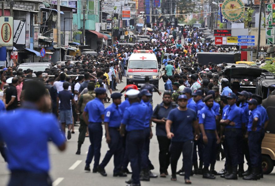Poliser i Sri Lanka försöker ge fri väg åt en ambulans.