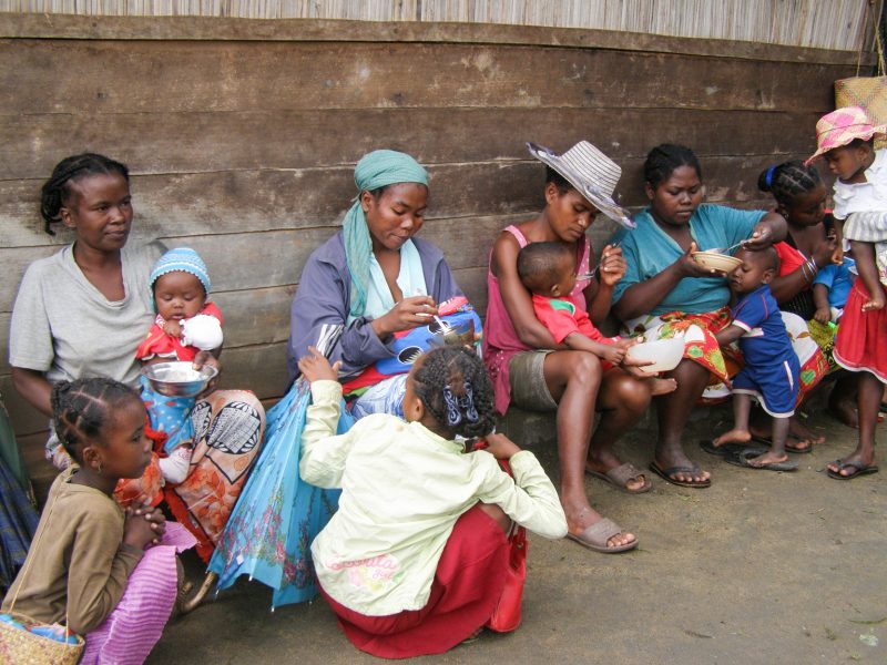 Mammor och barn väntar utanför en samlingslokal i byn Rantolava på Madagaskar där de ska få information om hur de ska kunna äta en mer näringsrik mat.