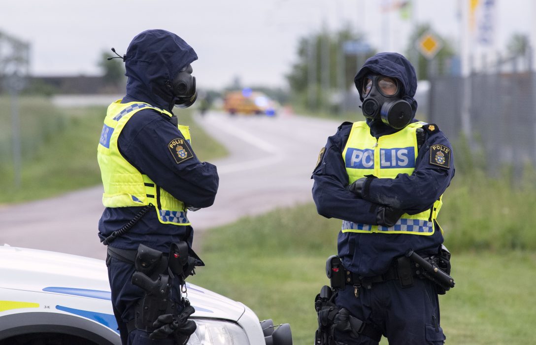 Polis i skyddsmask vaktar avspärrningarna kring ett farligt utsläpp av saltsyra i ett industriområde utanför Staffanstorp.
