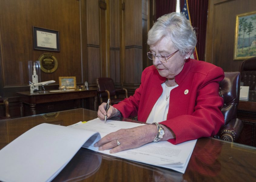 Republikanske delstatsguvernörens Kay Ivey skriver under abortlagen.