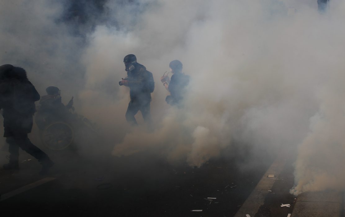Aktivister flydde från tårgas under en förstamajdemonstration i Paris.
