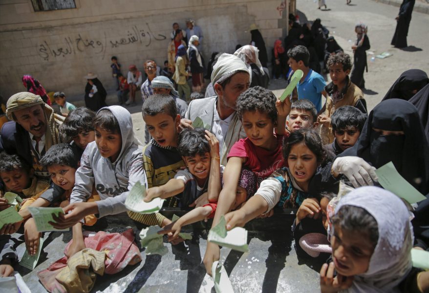 Jemeniter köar och visar dokument för att få mat.