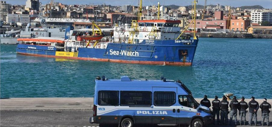 Italiensk polis tittar på Sea-Watch 3 när fartyget tidigare i år, efter två veckor till havs, lade till i Catania, Sicilien.