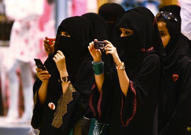 Kvinnor i Riyadh i Saudiarabien tar foton på sina barn under en ceremoni 2009.