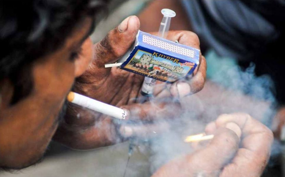 En narkotikamissbrukare i Pakistan med sin spruta.