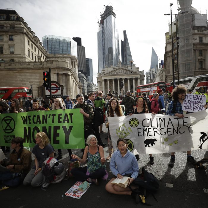 Extinction Rebellion climate change protesters block a road in central London, Thursday, April 25, 2019. The non-violent protest group, Extinction Rebellion, is seeking negotiations with the government on its demand to make slowing climate change a top priority. (AP Photo/Matt Dunham)
