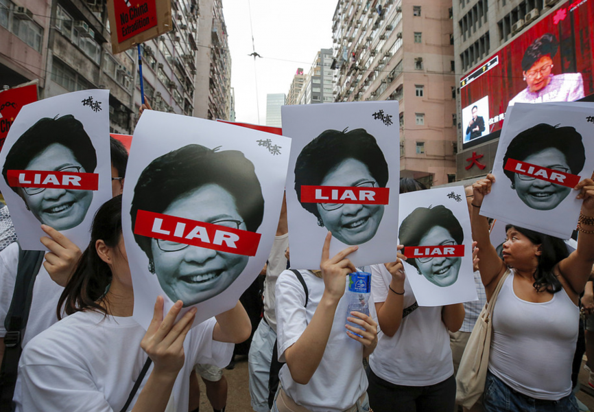 Foto: Kin Cheung/AP/TTDemonstranter med plakat föreställande Carrie Lam under söndagens protester.