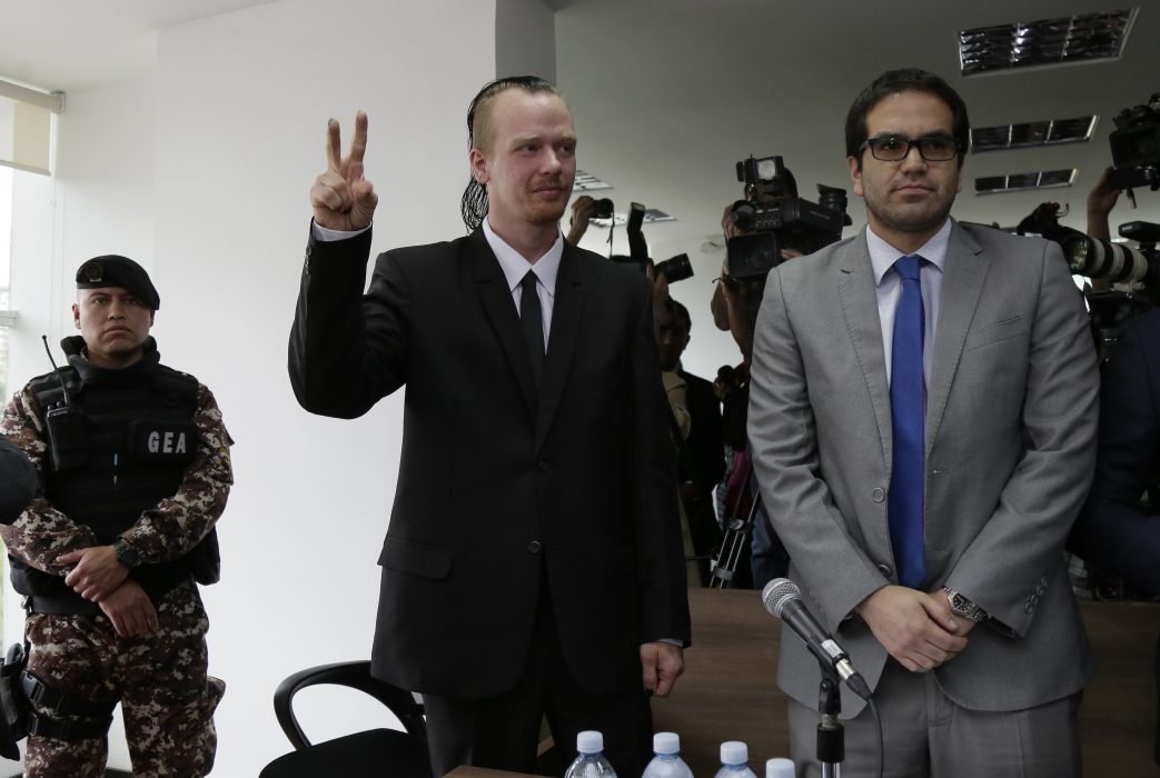 Ola Bini gör segertecknet på väg in i en domstol i Quito i början av maj.