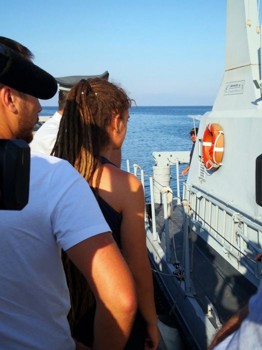 German captain of Sea-Watch 3 Carola Rackete, center with back to camera, is escorted onto an Italian finance police boat which will take her from the island of Lampedusa to a Sicilian port and then to courtroom in Agrigento where a judge will question her in the presence of her lawyers and prosecutors before deciding whether to uphold house arrest, Monday, July 1, 2019. On Saturday, RacketeÄôs defied ItalyÄôs anti-migrant interior minister, Matteo Salvini, and port authorities, by steering Sea-Watch 3 to LampedusaÄôs dock so 40 migrants, which the ship rescued on June 12, could disembark. (Elio Desiderio/ANSA via AP)