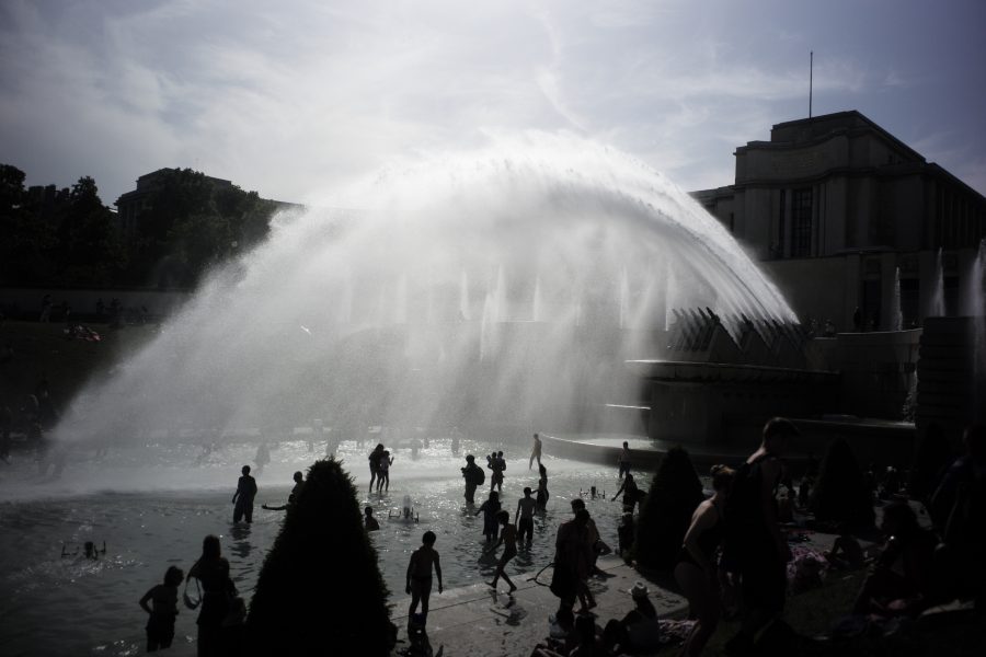 Människor svalkar sig i fontänen i Trocaderoträdgården i Paris.