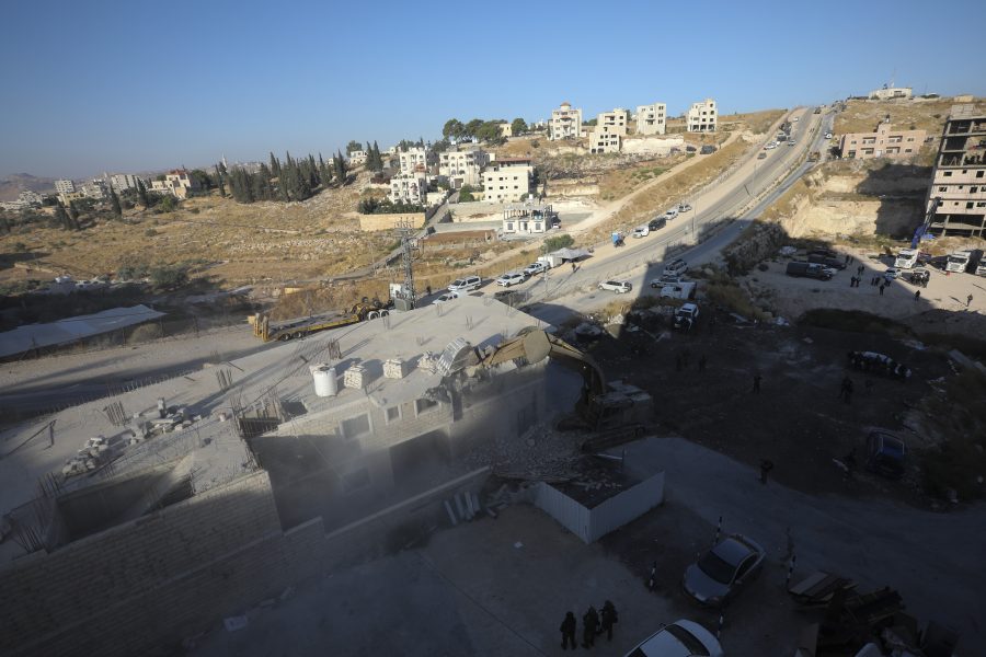 En israelisk militär bulldozer river en byggnad i en palestinsk by söder om Jerusalem.