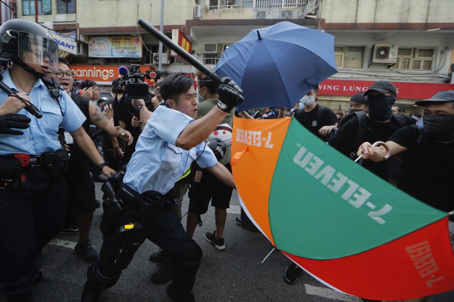 En polis går till attack mot demonstranter i Hongkong under lördagens protester.