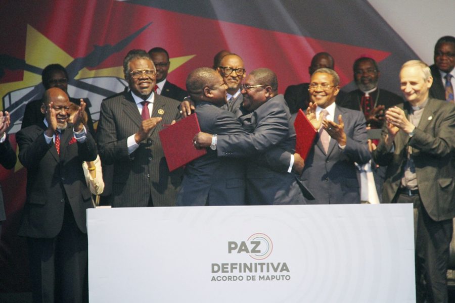 Moçambiques president Filipe Nyusi, till höger, och Renamoledaren Ossufo Momade omfamnar varandra efter undertecknandet av fredsavtalet.