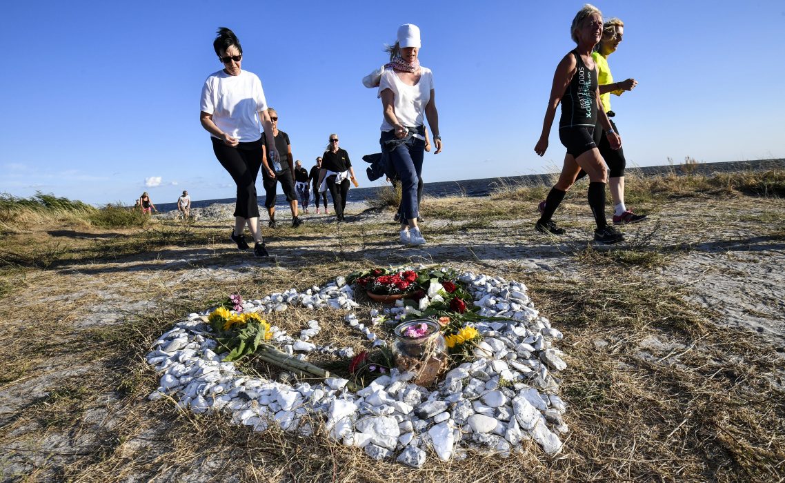 Deltagare i minnesloppet i fjol springer förbi minnesplatsen för Kim Wall på stranden i Gislövs läge.
