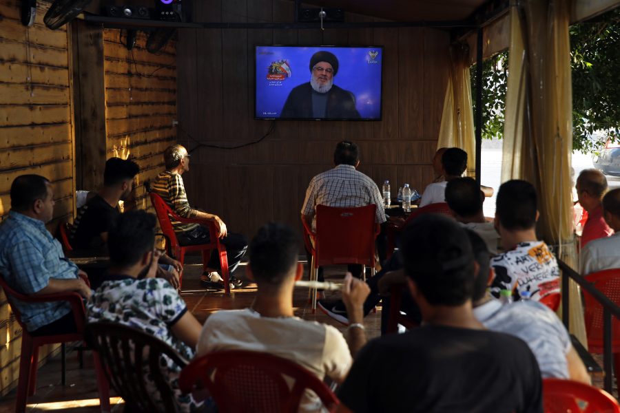 Söndag 25 augusti i Beiruts södra förorter: människor sitter på ett café och lyssnar på ett tal av Hizbollahs ledare Hassan Nasrallah.
