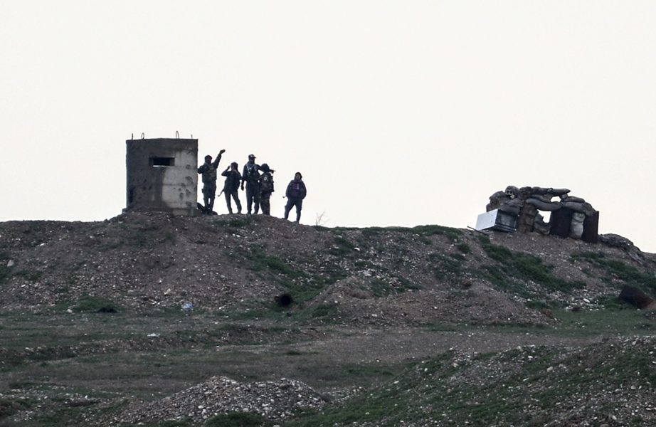 Soldater ur den kurdiska YPG-milisen vid en postering vid staden Kobane, nära gränsen mot Turkiet.