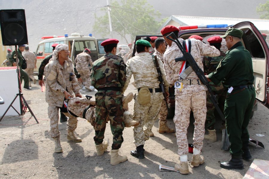 Soldater hjälper en skadad kollega efter attacken mot en militärparad i Aden, Jemen.