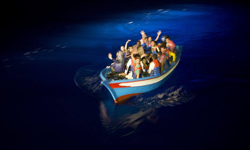 En träbåt närmar sig Aquarius, MSF:s och SOS Mediterranees båt som beslagtogs av Italien förra året.