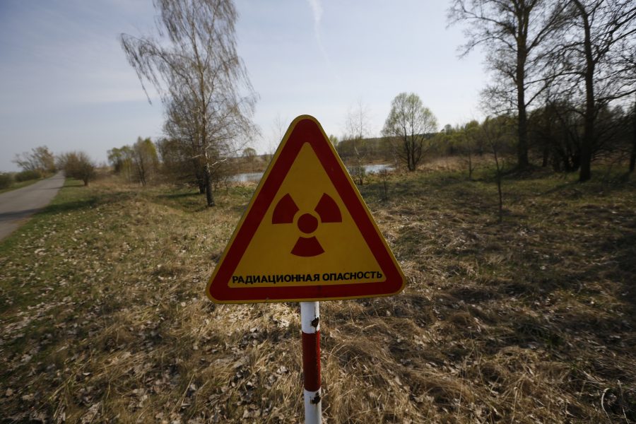 En varningsskylt vid en vägspärr in till den avstängda zonen runt Tjernobyl i Ukraina.