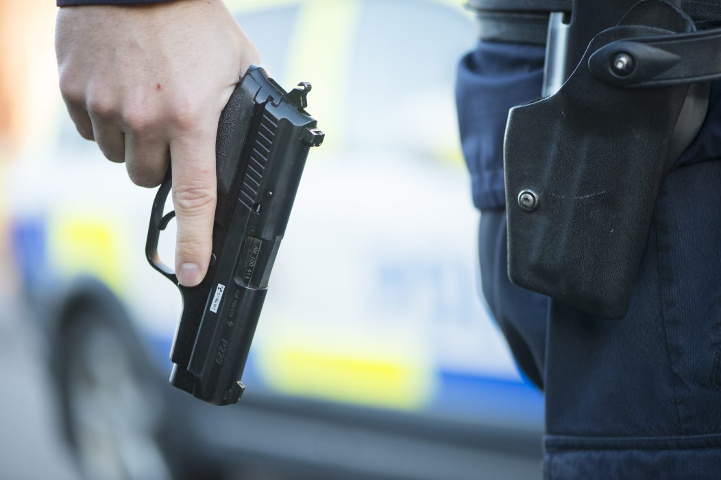 En polisman har åtalats, misstänkt för att ha riktat sitt tjänstevapen mot en kollega.