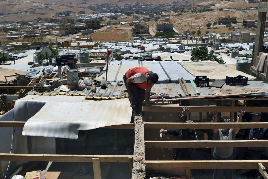 Syriska flyktingar förstör en betongvägg som de har byggt i sitt tält i ett flyktingläger i Arsal i östra Libanon, på order av libanesiska myndigheter.