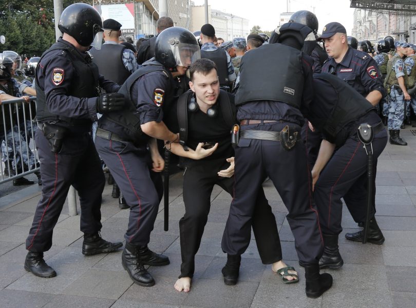 Ryska poliser griper en man under helgens demonstrationer i Moskva.