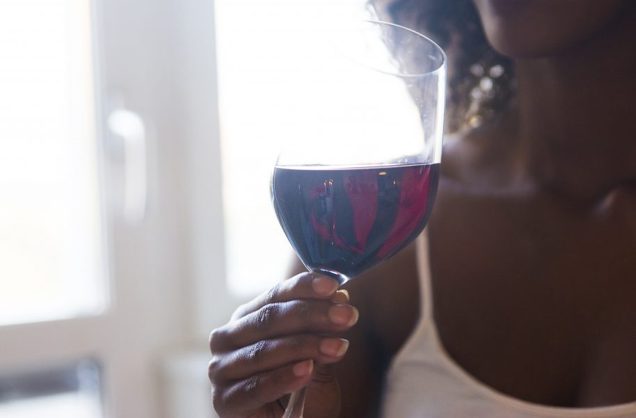  Kvinna dricker ett glas rödvin.
