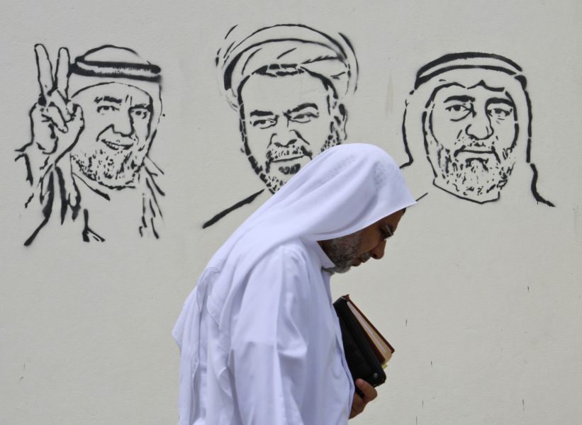 En man från Bahrain passerar bilder på fängslade oppositionella på en vägg i huvudstaden Barbar.