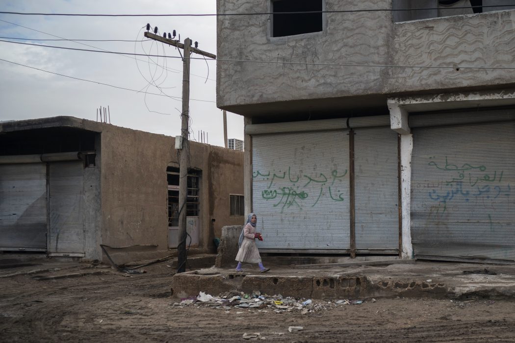 En flicka går förbi i ett område i staden Hajin i östra Syrien, några veckor efter att staden återtagits från terrorgruppen IS i en offensiv som enligt FN:s utredare skördade många civila dödsoffer.