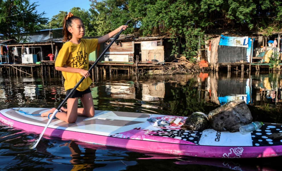 Tolvåriga Ralyn Satidtanasarn paddlar i Bangkok för att fiska upp skräp.