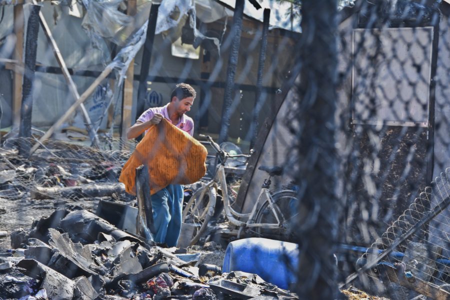 En man samlar ihop sina ägodelar efter en brand på den grekiska ön Samos i mitten på oktober.