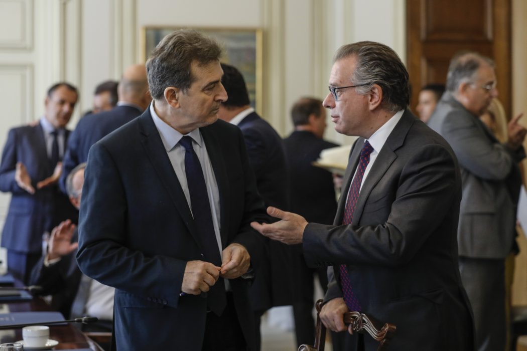 Från höger: Giorgios Koumoutsakos, minister med ansvar för migrationspolitik, och Michalis Chrisochoidis, Greklands minister för medborgarskydd, samtalar under måndagens möte i det grekiska beslutsfattande kabinettet.