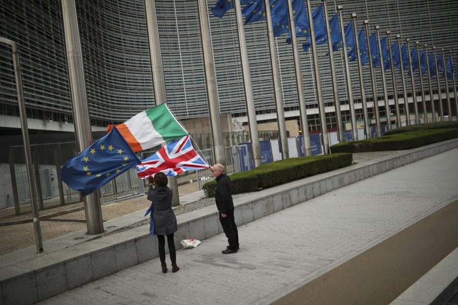 Två personer med EU:s, Irland och Storbritanniens flaggor under brexitförhandlarnas möte i Bryssel.