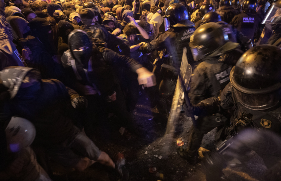 Demonstranter drabbar samman med kravallutrustad polis i Barcelona under tisdagskvällen.