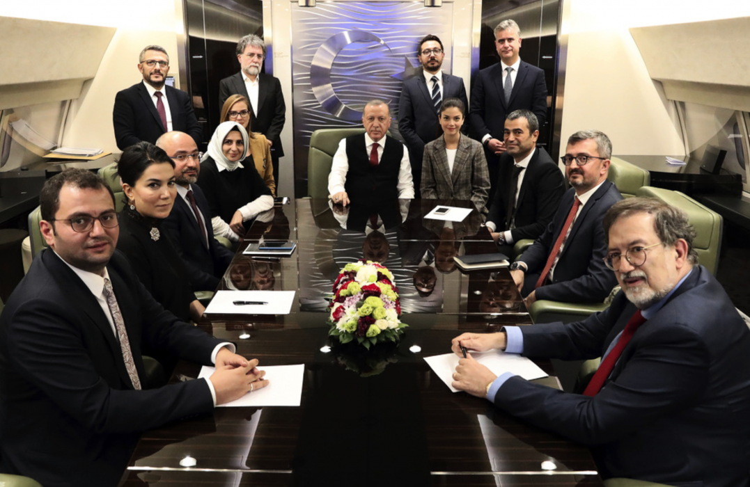 Turkiets president Recep Tayyip Erdogan omgiven av journalister och rådgivare ombord det flygplan där han svarade på frågor från inhemsk media.