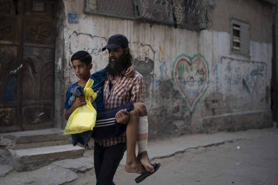 En tolvårig pojke bärs av sin pappa sedan han blivit vårdad på ett sjukhus i Gaza city.