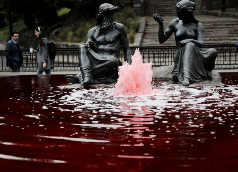Vattnet från en fontän färgad röd av demonstranter i Santiago.