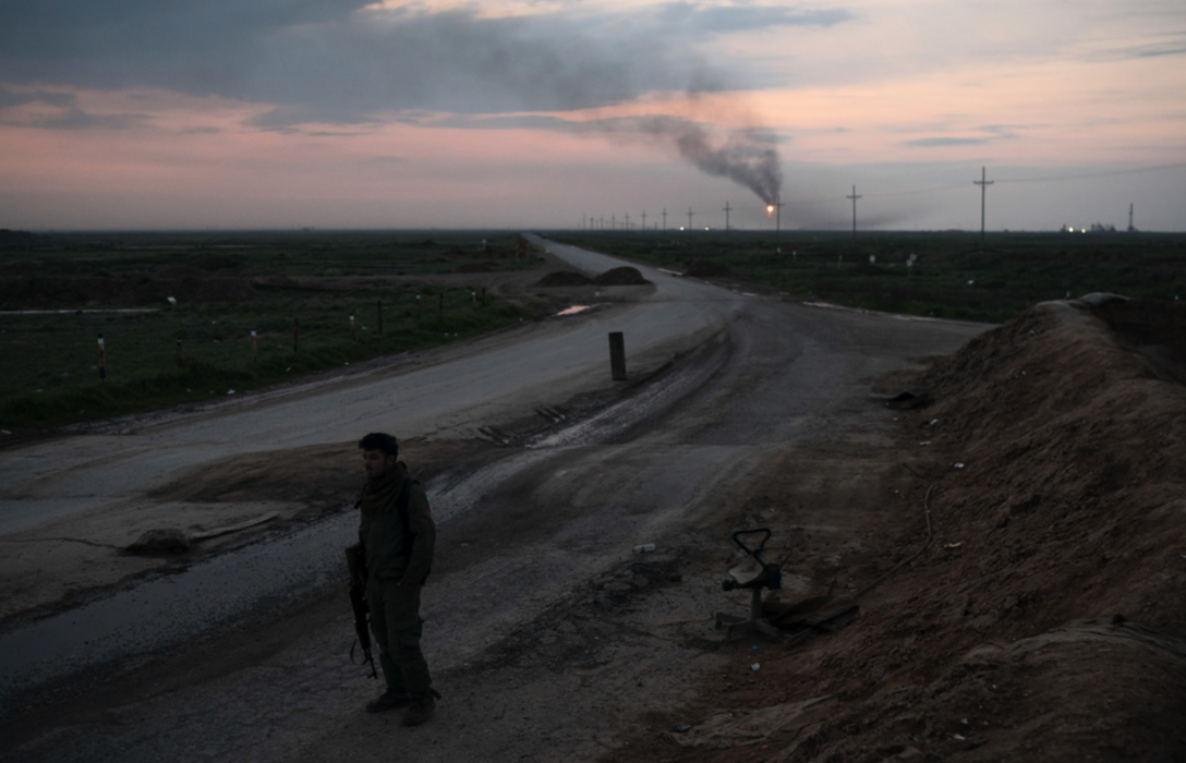 En milisman från kurdiska SDF på vakt nära ett oljefält i norra Syrien förra vintern.