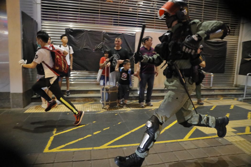 Polis jagar en demonstrant i Hongkong under söndagen.