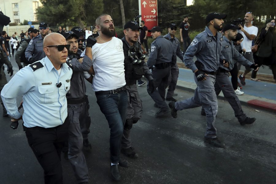 Israelisk polis griper en palestinier under en protest utanför sjukhuset där Samir Arbeed ligger i respirator med njursvikt och brutna revben efter tortyr i häktet.