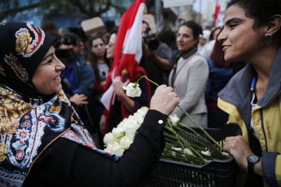 En kristen kvinna ger blommor till en muslimsk kvinna vid en tidigare frontlinje mellan kristna och muslimska stadsdelar i Beirut.
