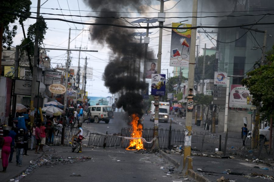 Demonstranter har stuckit en barrikad i brand på en gata i Delmas utanför den haitiska huvudstaden Port-au-Prince.