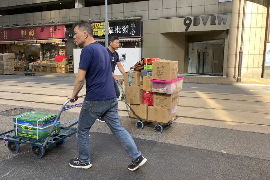 Hongkongbor passerar ingången till den kontorsbyggnad där det kinesiska bolag som den avhoppade spionen Wang Liqiang arbetade för har sitt högkvarter.