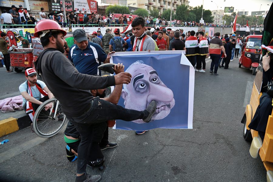 Irakiska demonstranter med ett nidporträtt av premiärminister Adil Abd al-Mahdi under förra helgens protester.