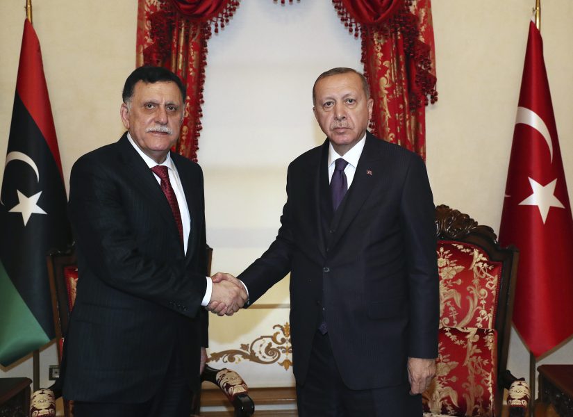 Turkiets president Recep Tayyip Erdogan, till höger, skakar hand med Libyens internationellt erkända regerings premiärminister, Fayez al-Sarraj, under ett möte i Istanbul den 15 december.