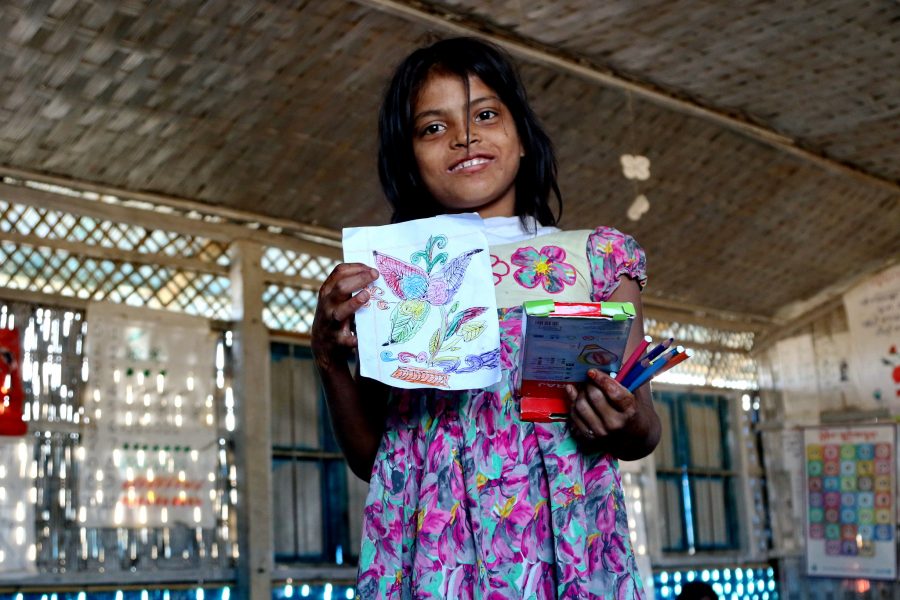 En rohingyisk flicka visar stolt upp en teckning hon gjort i en skola driven av Unicef i Balukhali-lägret i Bangladesh.