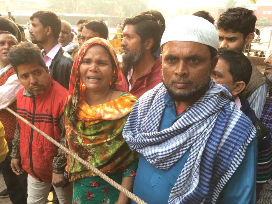 Noor Jehan i mitten är på väg att identifiera sin far som dog i branden på en fabrik i Delhi den 8 december.